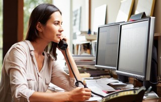 Woman talking on desk phone