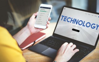 Woman on laptop and holding mobile phone