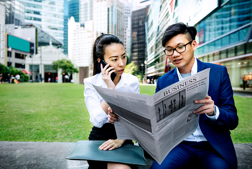 Young professionals reading business news