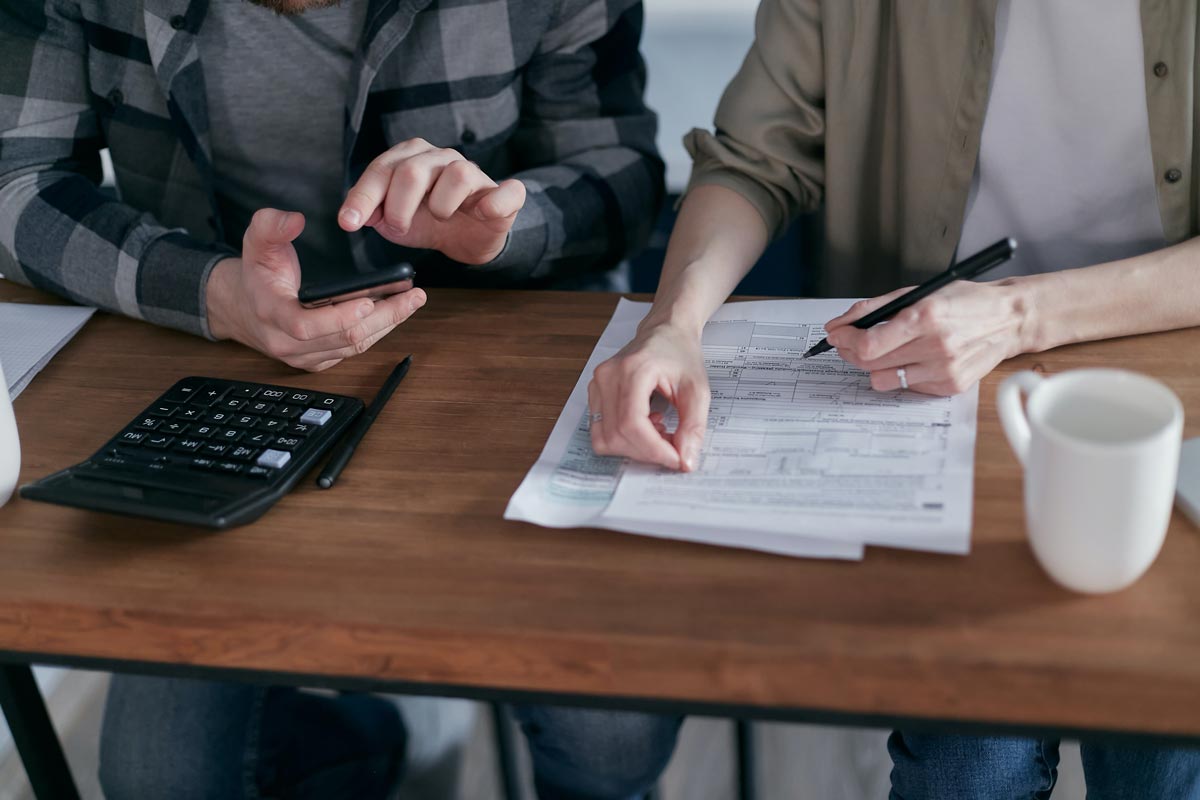 pro-rata_blog Man and woman at desk with paperwork and calculator