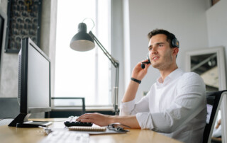 Man on headset sitting behind computer