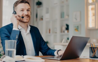 Man on headset sitting in front of a laptop