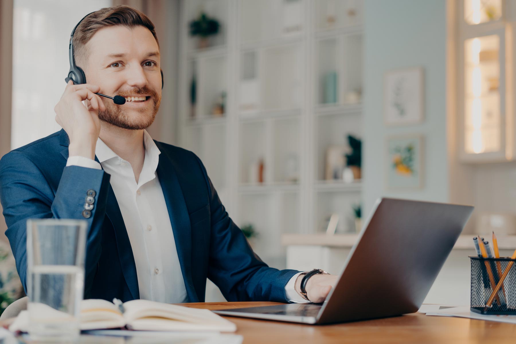Man on headset sitting in front of a laptop