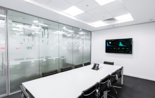 an empty meeting room with large commercial display on wall showing business charts and graphs