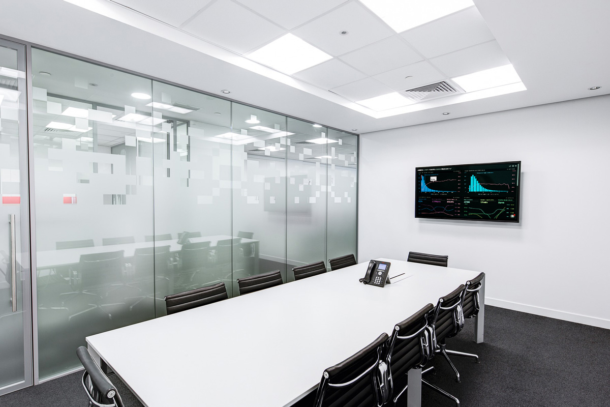 an empty meeting room with large commercial display on wall showing business charts and graphs
