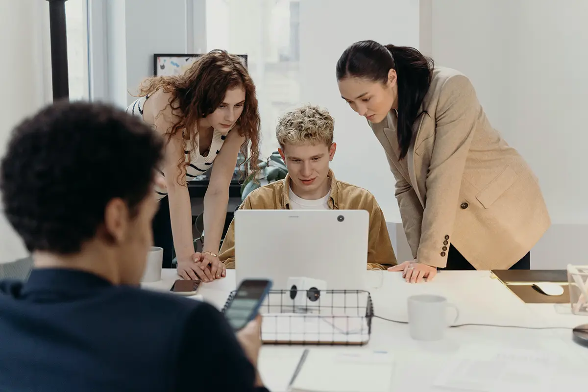 Colleagues gathered around a laptop
